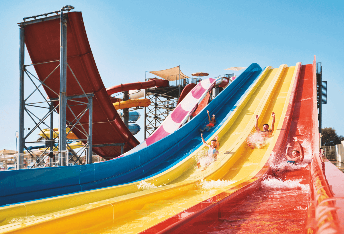 A family of 4 going down slides at the Globales Bouganvilla waterpark