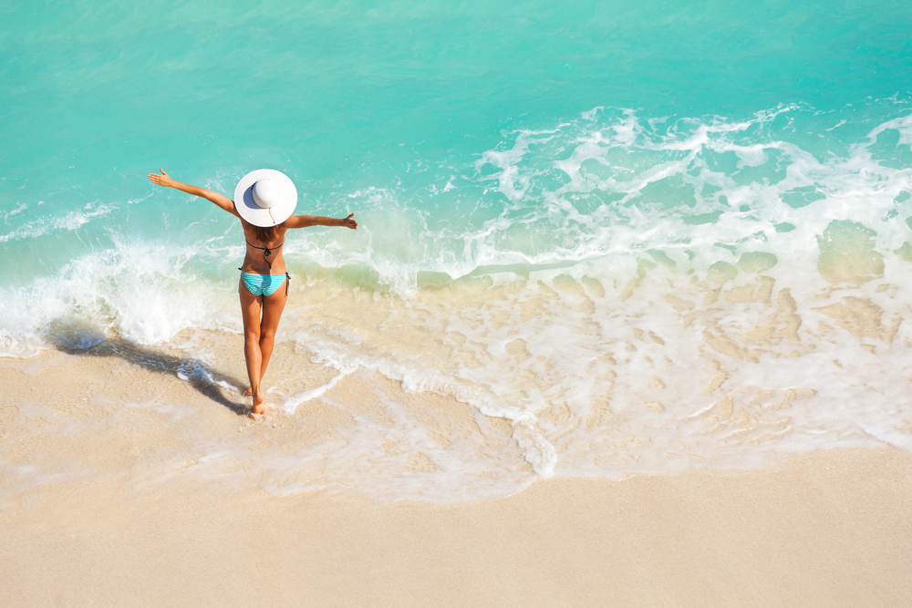 Young woman walking into the sea on a beach